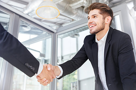 Two successful businessmen shaking hands on business meeting in
