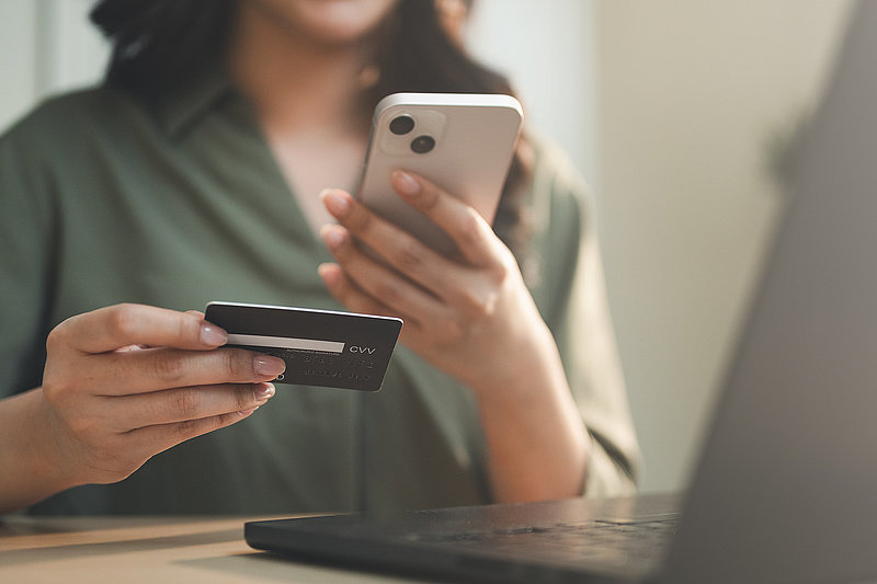Woman holding credit card and smartphone for online payment. Concept of ecommerce, digital wallet, secure transaction, and cashless shopping via mobile banking and modern financial technology.