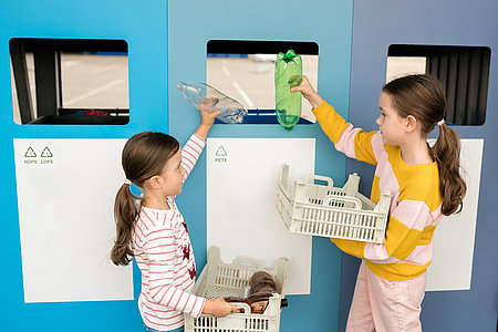 Kids sorting plastic by polymer type and taking out plastic trash in recycling centre. Sustainble lifestyle concept. National recycling week.