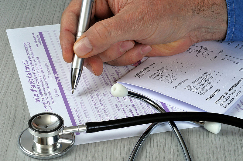 Médecin remplissant un arrêt de travail pour une grossesse