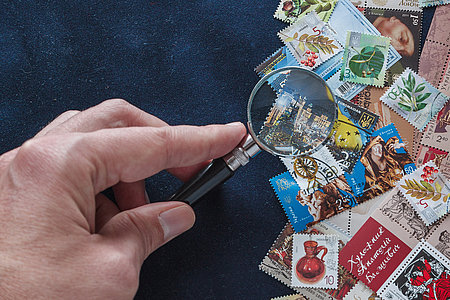 Composition of stamps and magnifying glass on a blue background. Ukrainian stamps