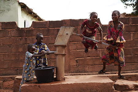 West African Children Filling Up A Water Bucket At The Borehole